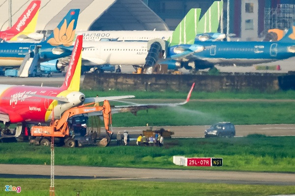 Khi máy bay của hãng VietJet trở lại đường băng, lực lượng chức năng đã xịt nước để loại bỏ bùn đất bám trên vỏ máy khi trượt ra thảm cỏ.