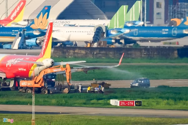 Khi máy bay của hãng VietJet trở lại đường băng, lực lượng chức năng đã xịt nước để loại bỏ bùn đất bám trên vỏ máy khi trượt ra thảm cỏ.