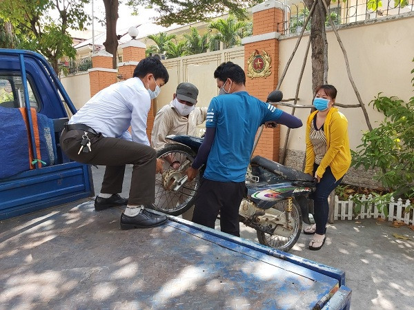 Chiếc xe bị ngâm dưới nước lâu ngày nên không thể dắt đi được phải khiêng lên xe ô tô tải nhỏ để chở về. Ảnh Nam Dương