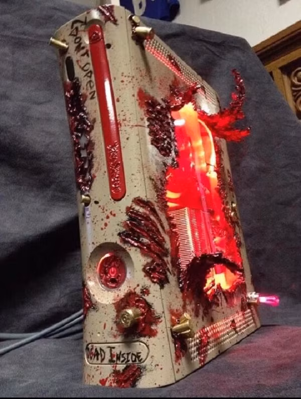 Những con zombie khát máu đã truyền cảm hứng cho modder Csmodsandart tạo nên một chiếc Xbox 360 máu me, bị "xé toạc" để lộ ánh sáng đỏ kỳ quái bên trong.