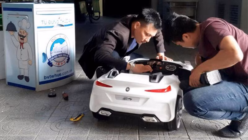  Robot Tâm An được cải tiến từ nhiều thành phần bao gồm xe ô tô BMW Z4 đồ chơi điều khiển từ xa dành cho trẻ em. Phần trên được lắp thêm 1 thùng chứa đồ ngăn gọn gàng. Ảnh: GD&amp;XH