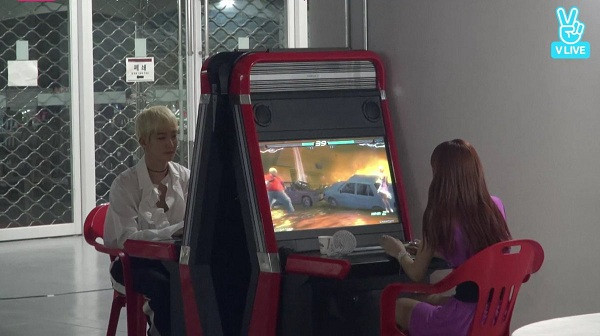 Hình ảnh Lisa đang say mê với một tựa game trên máy chơi game ở hậu trường Korea Music Festival 2017. Đối diện là Seung Hoon (Winner).