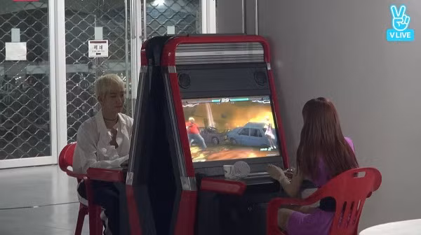 Hình ảnh Lisa đang say mê với một tựa game trên máy chơi game ở hậu trường Korea Music Festival 2017. Đối diện là Seung Hoon (Winner).