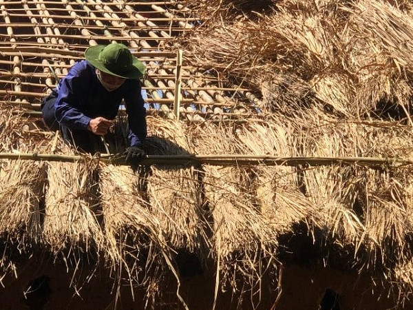 Một trong những người thợ tiến hành lợp tranh mái. Kỳ lạ chuyện làm dâu của người Hà Nhì | VTC Now. Nguồn: Youtube