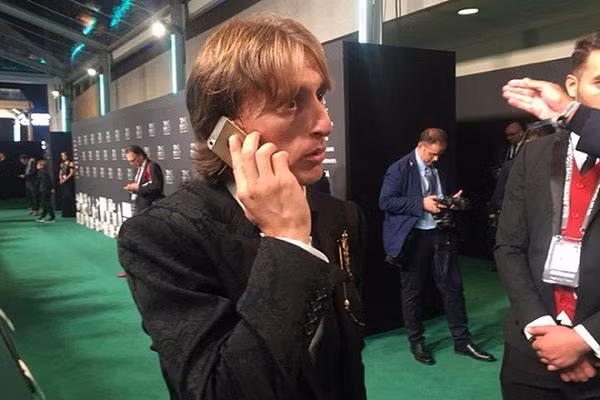 Khoảnh khắc nhận danh hiệu The Best 2018 của FIFA dành cho Cầu thủ xuất sắc nhất năm, cũng là thời điểm tiền vệ nổi tiếng người Croatia - Luka Modric bị bắt gặp khi đang gọi điện thoại bằng chiếc iPhone 5S khá lỗi thời. Được biết, vào thời điểm đó anh đang thi đấu cho CLB Hoàng gia Tây Ban Nha Real Madrid với mức lương 180.000 bảng/tuần (hơn 5 tỷ đồng). Ảnh: 24h.com.vn