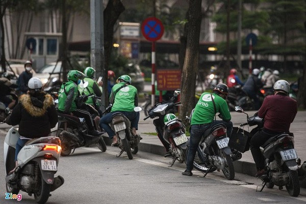 Cùng với sự đông đúc của các phương tiện, nhiều cửa hàng, dịch vụ vội vã làm việc đón khách. Tại nút giao Liễu Giai - Đào Tấn, rất nhiều người mặc áo xe ôm công nghệ ngồi xếp hàng bên lề đường.