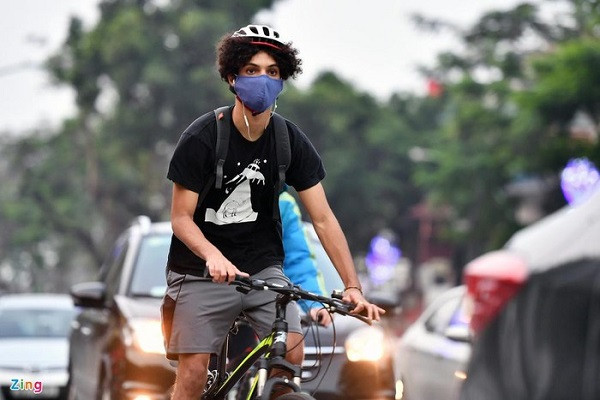 Một thanh niên người nước ngoài đạp xe len lỏi giữa dòng phương tiện trên đường Thanh Niên.
