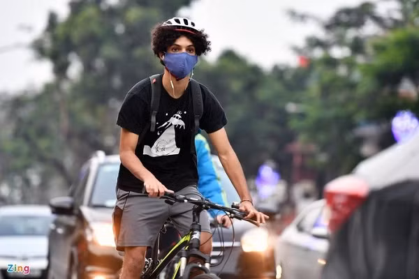Một thanh niên người nước ngoài đạp xe len lỏi giữa dòng phương tiện trên đường Thanh Niên.