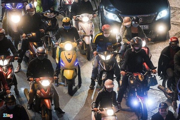 Người tham gia giao thông chờ tín hiệu đèn tại ngã tư Láng - Lê Văn Lương khi trời đã tối.