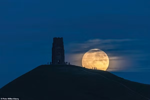 Hình ảnh ấn tượng được ghi lại trên ngọn đồi Glastonbury Tor, Somerset, Anh. Lúc này siêu trăng xuất hiện có kích thước khổng lồ tương đương tháp St.Michael tại Glastonbury.