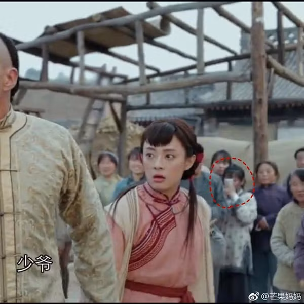 Đây không phải là lần đầu tiên điện thoại xuất hiện trong một bộ phim cổ trang Hoa ngữ. Tập 11 của bộ phim “Năm ấy hoa nở trăng vừa tròn” từng gẫu bão màn ảnh nhỏ đạt rating cao đột biến, không chỉ bởi tình tiết gay cấn, mà còn ở chi tiết một diễn viên quần chúng rút máy điện thoại ra chụp ảnh hai nhân vật chính, sau đó vội vàng cất đi. Ảnh: sina