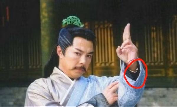 Nhiều lớp áo cổ trang cũng không đủ để che đi phụ kiện đồng hồ đeo tay hiện đại của Dương Tiêu (Trương Thiết Lâm) trong Ỷ Thiên Đồ Long Ký 2003.