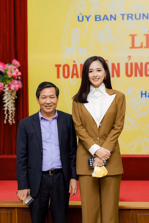 Hoa hậu Việt Nam xuất hiện cùng bộ suit kín đáo, thanh lịch, phụ kiện đi kèm thay vì trang sức đắt tiền, là khẩu trang và chiếc điện thoại mà cô đang sở hữu. Không khó để nhận ra đây là smartphone của Apple.