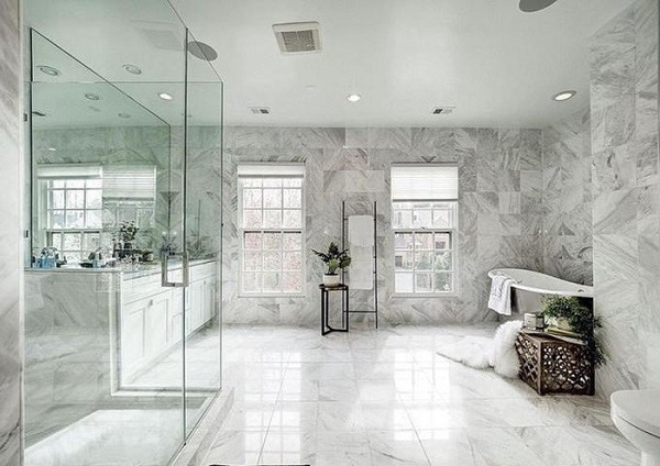 Phòng tắm là không gian khá lớn được lát đá xung quanh, cửa sổ đón ánh sáng tự nhiên với điểm nhấn là những chậu cây nhỏ.