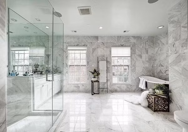 Phòng tắm là không gian khá lớn được lát đá xung quanh, cửa sổ đón ánh sáng tự nhiên với điểm nhấn là những chậu cây nhỏ.