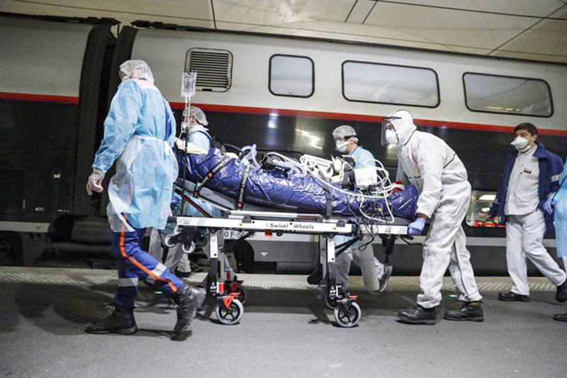 Ngày 1/4 bệnh nhân nhiễm COVID-19 được nhân viên y tế vận chuyển đến đoàn tàu đang chờ tại ga đường sắt Gare d'Austerlitz ở Paris.