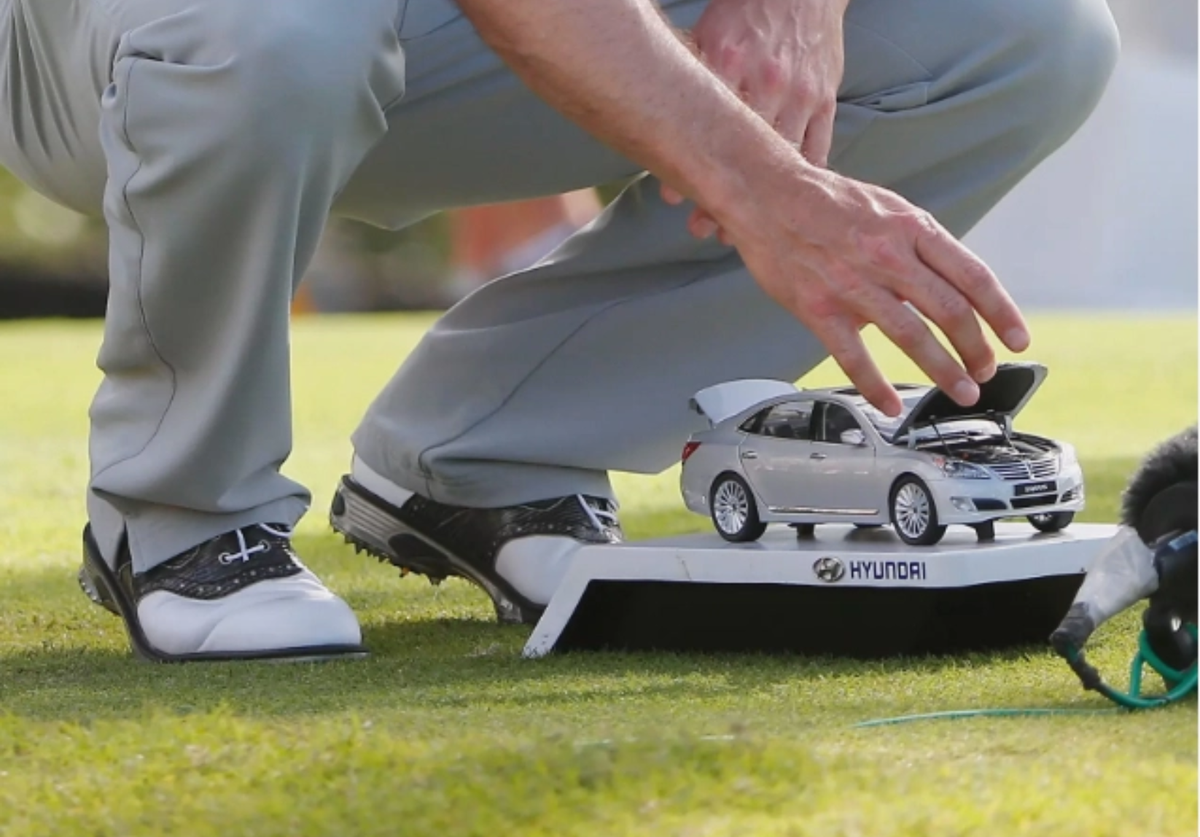 Bàn tay trong bức ảnh là Zach Johnson. Golfer người Mỹ đã không thể cưỡng lại tee marker mô hình xe Huyndai tại Huyndai Tournament of Champions 2014.