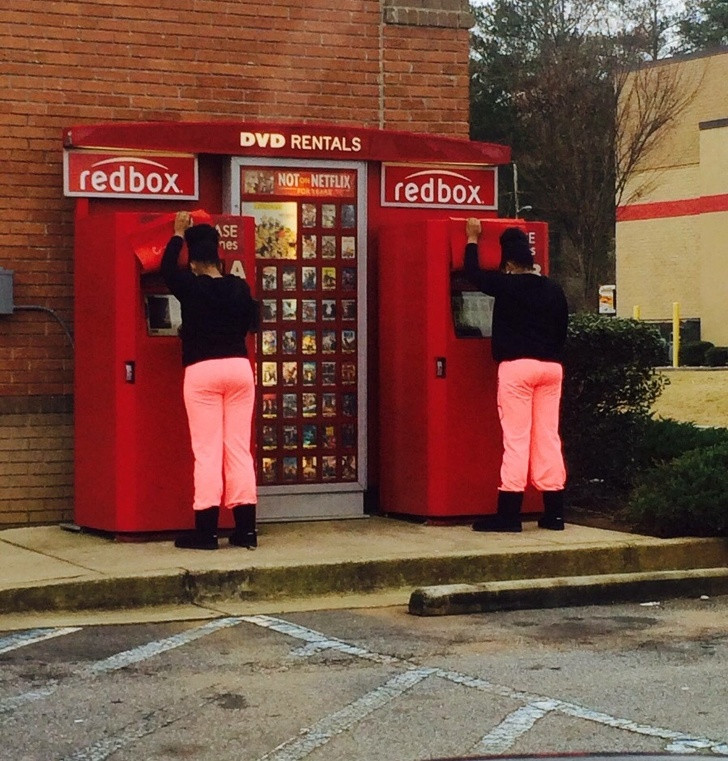 Hai người phụ nữ tình cờ mặc đồ giống nhau, thậm chí cả kiểu tóc cũng giống, đang cùng làm một hành động.