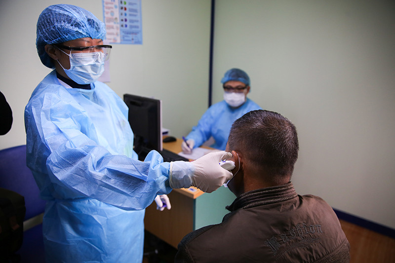 Người dân tới khám được đo thân nhiệt tại phòng khám sàng lọc.