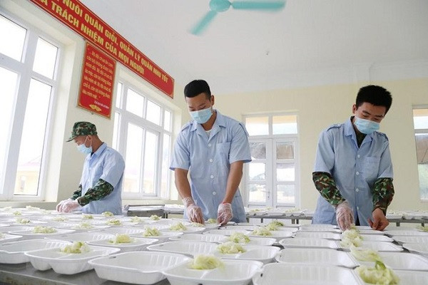 Anh nuôi của các đơn vị quân đội chuẩn bị suất ăn đảm bảo dinh dưỡng cho người thực hiện cách ly tập trung tại các đơn vị quân đội. (Ảnh: Dương Giang/TTXVN)
