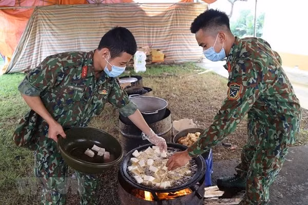 Các chiến sỹ Trung đoàn 58, Sư đoàn 308 (Quân đoàn 1) chuẩn bị lương thực, thực phẩm chăm lo bữa ăn cho người thực hiện cách ly tập trung tại đơn vị. (Ảnh: Dương Giang/TTXVN)