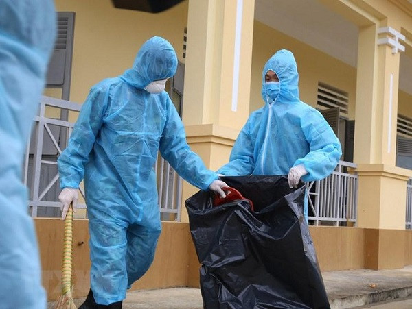 Lực lượng khử trùng, xử lý môi trường xung quanh khu vực cách ly nhằm hạn chế lây lan dịch bệnh. (Ảnh: Dương Giang/TTXVN)