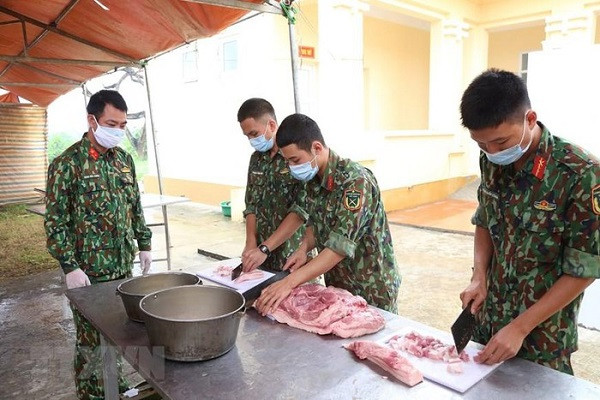 Các chiến sỹ Trung đoàn 58, Sư đoàn 308 (Quân đoàn 1) chuẩn bị lương thực, thực phẩm chăm lo bữa ăn cho người thực hiện cách ly tập trung tại đơn vị. (Ảnh: Dương Giang/TTXVN)