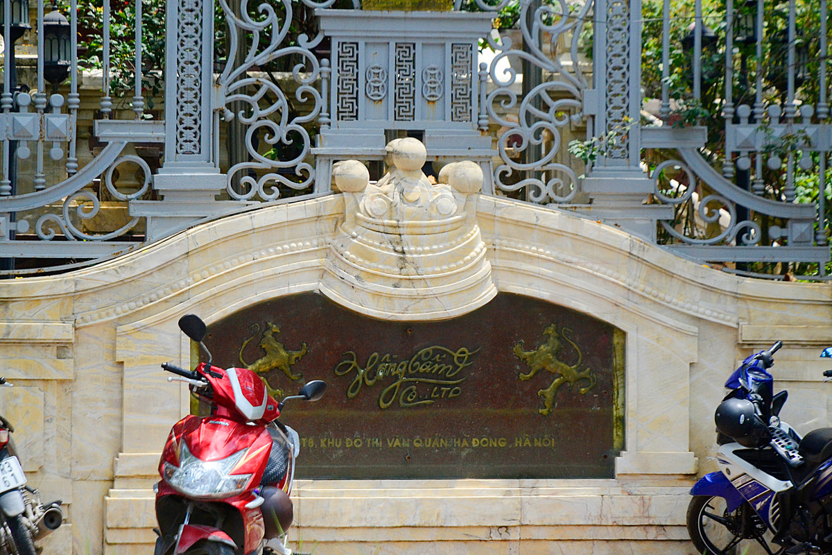 Trước cửa nhà có biển tên biệt thự "Hồng Cẩm" với thiết kế đá kiên cố, họa tiết hoa văn tối giản.