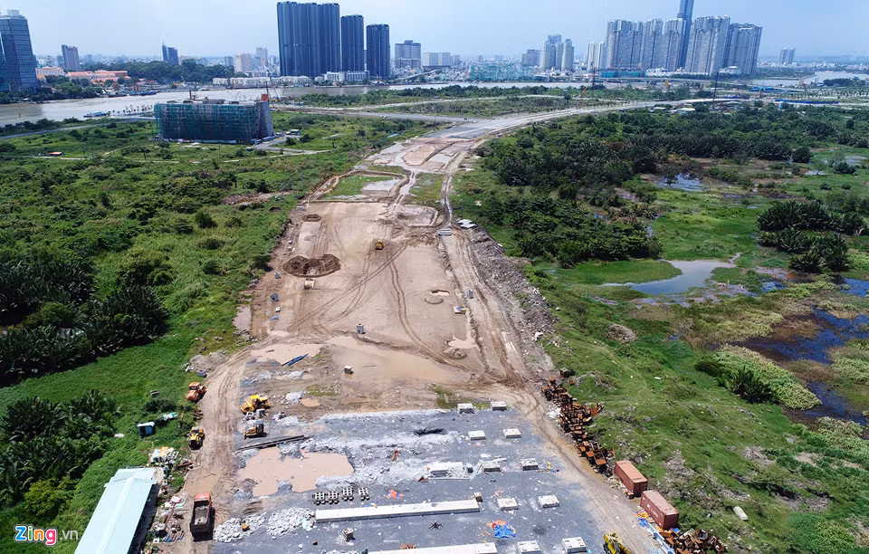 Nhưng một đoạn dài của tuyến giữa trung tâm khu đô thị (R1) hiện vẫn chỉ là nền đất. Tuyến đường này thuộc đường cấp 1, là trục xương sống kết nối các khu chức năng của Thủ Thiêm. Hạng mục đường vượt qua cửa hầm Thủ Thiêm vẫn đang ngổn ngang. Ảnh: Zing.