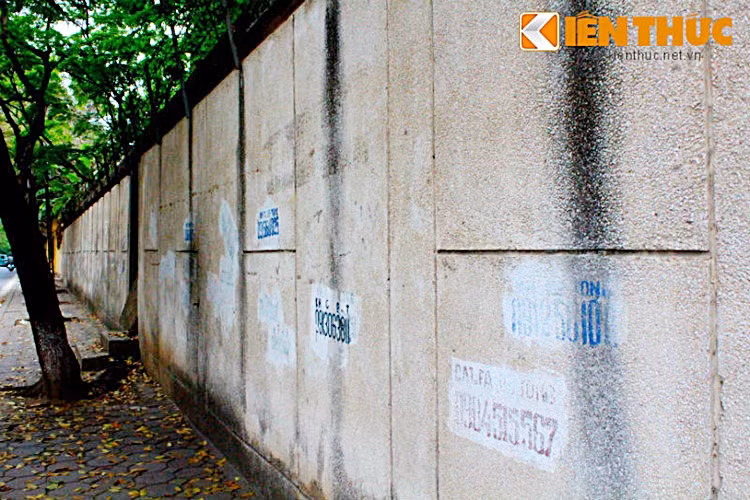 Bức tường phía góc trái ngôi nhà bị phủ kín nhiều hình ảnh, chữ viết bằng sơn...
