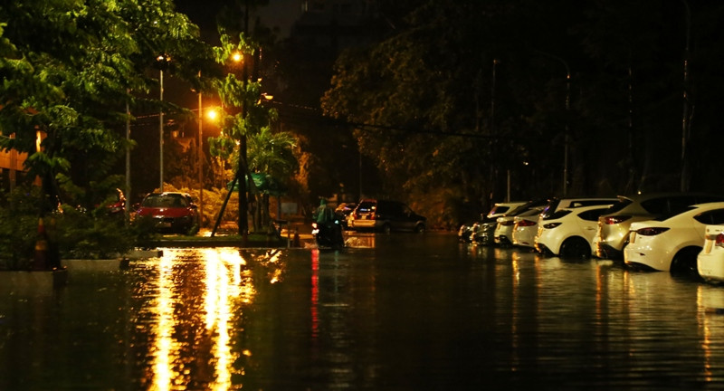 Nước ngập trên diện rộng đến gần nửa bánh xe ô tô đậu trong khuông viên.