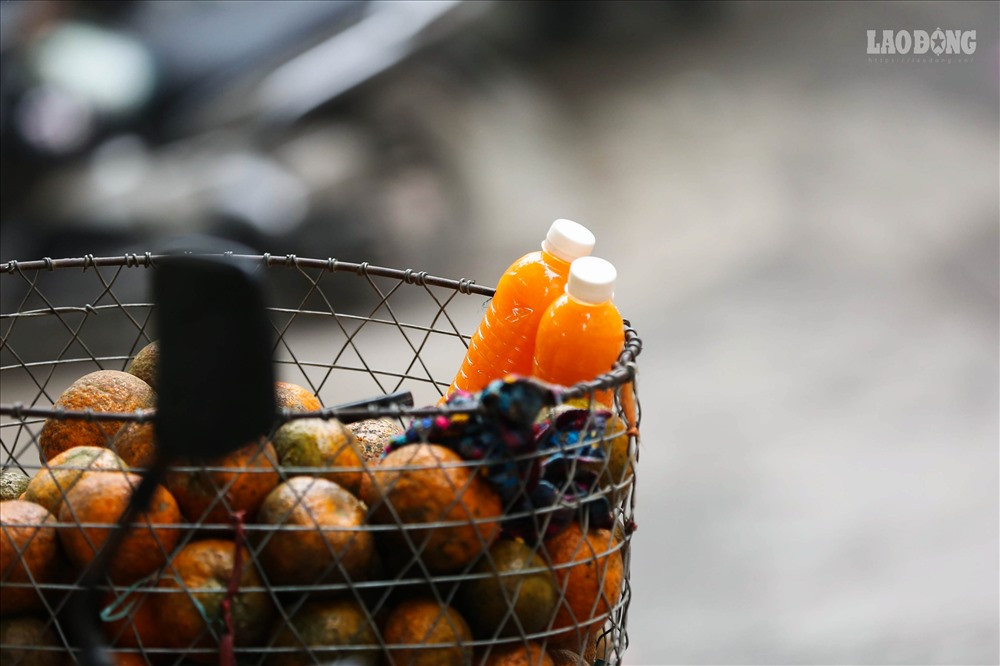 Để bán được những chai cam, những người bán rong phải đứng dưới cái nắng gay gắt của Hà Nội.