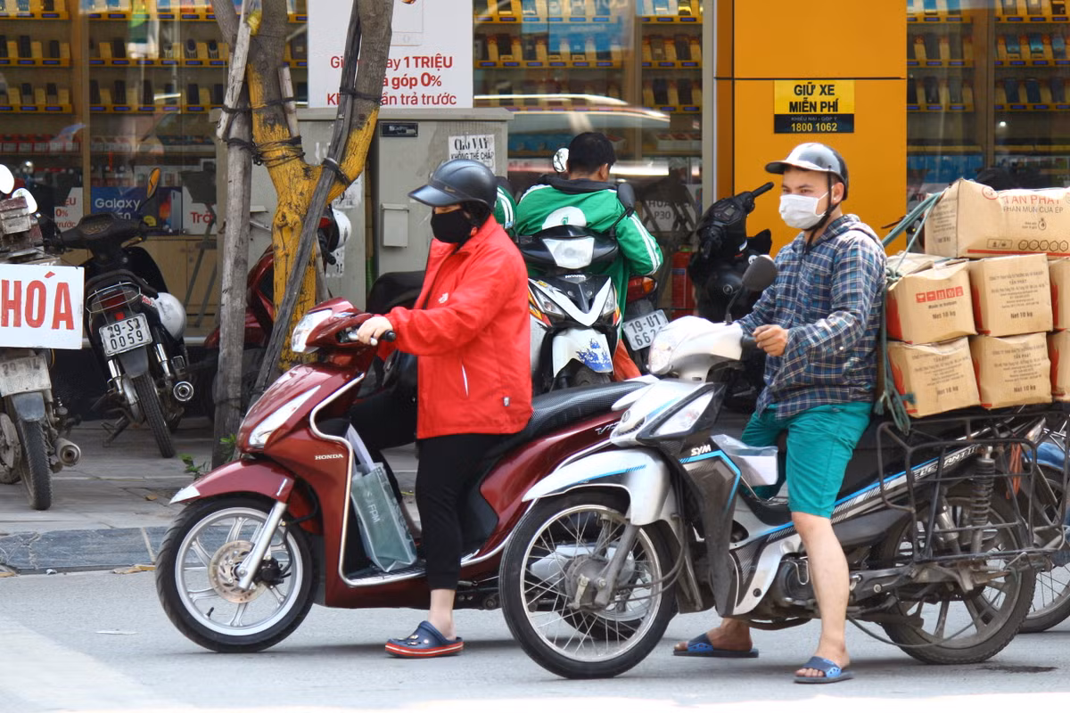 Thậm chí, người phụ nữ áo đỏ còn mặc cả áo khoác dày để chống lại cái nắng Hà Nội.