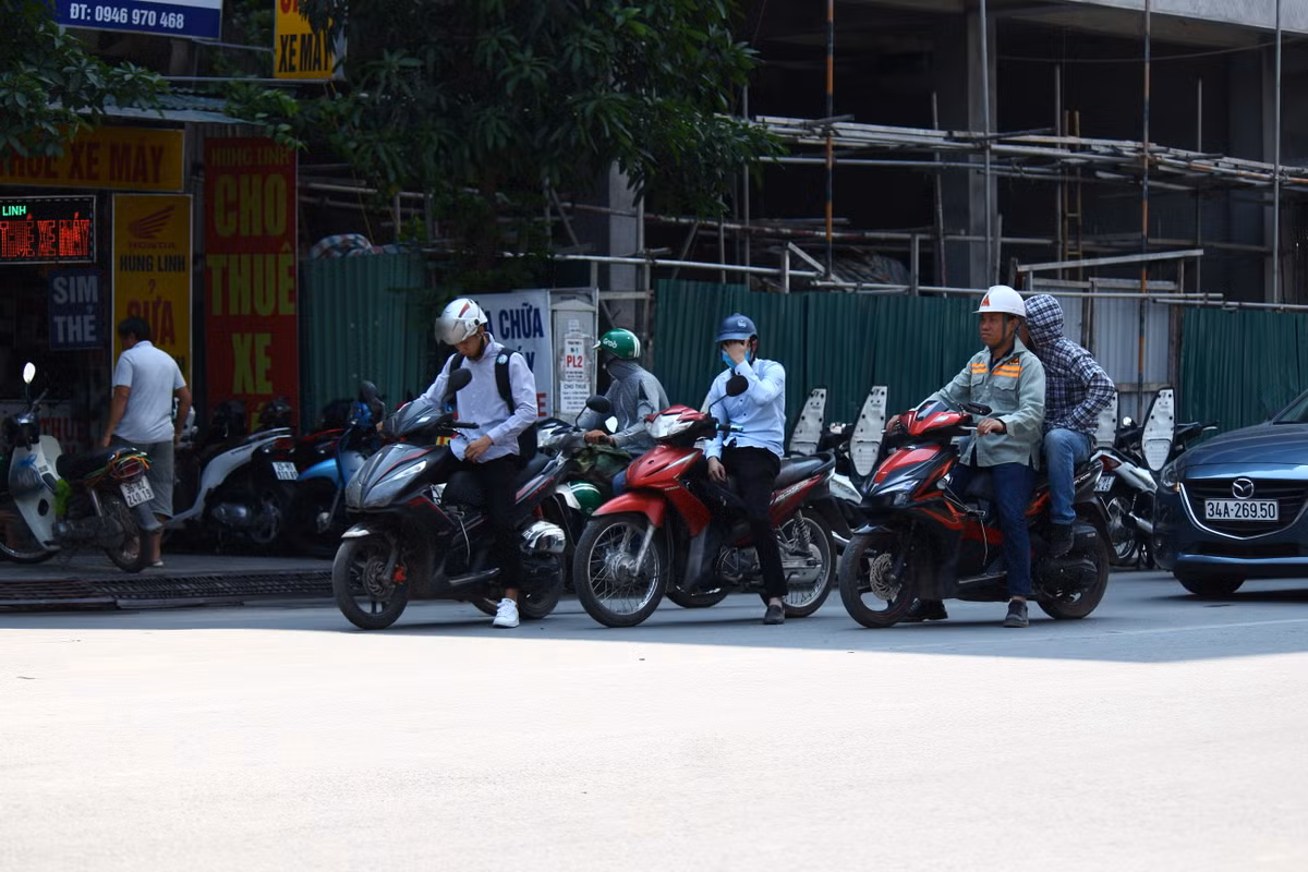 Tận dụng bóng râm của tòa nhà bên đường để tránh nắng.