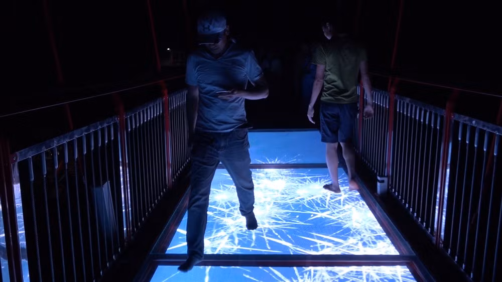 Ngoài phần kính trong, trên cầu còn có 2 màn hình lớn với hiệu ứng phần mềm. Với 56 hiệu ứng khác nhau cho mỗi màn hình, du khách sẽ có cảm giác đi trên thảm hoa, bể cá hoặc cảm giác mảnh kính vỡ với màn hình led tiêu chuẩn và tiếng hiệu ứng phát ra bên thành cầu cho cảm giác sống động.