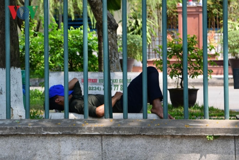 Ghế đá dưới tán cây xanh là nơi được nhiều người lựa chọn để ngả lưng , một người nhà trông bệnh tranh thủ ngủ trưa trong khuôn viên bệnh viện TW Huế.