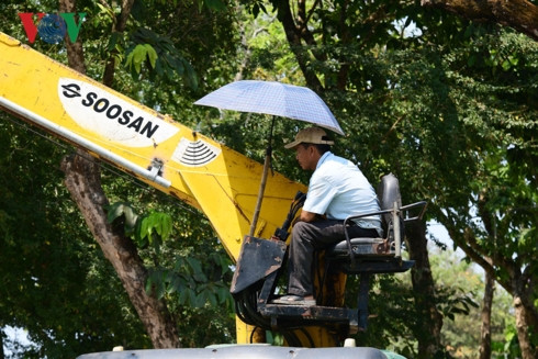 Đủ cách chống nắng nóng của công nhân đang chuẩn bị cho Festival nghề truyền thống chuẩn bị khai mạc tại Huế.