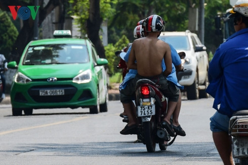 Một thanh niên cởi trần khi di chuyển vì quá nóng.
