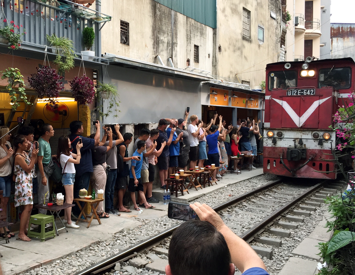 Du khách lạ lẫm với cảnh tượng tàu chạy sát bàn cà phê. Nhiều người cho biết đây là trải nghiệm thú vị. Một số ý kiến không nhỏ khác thì cho rằng, việc ngồi uống cà phê ở đây chẳng khác nào thách thức thần chết, tiềm ẩn nguy cơ tai nạn cao.