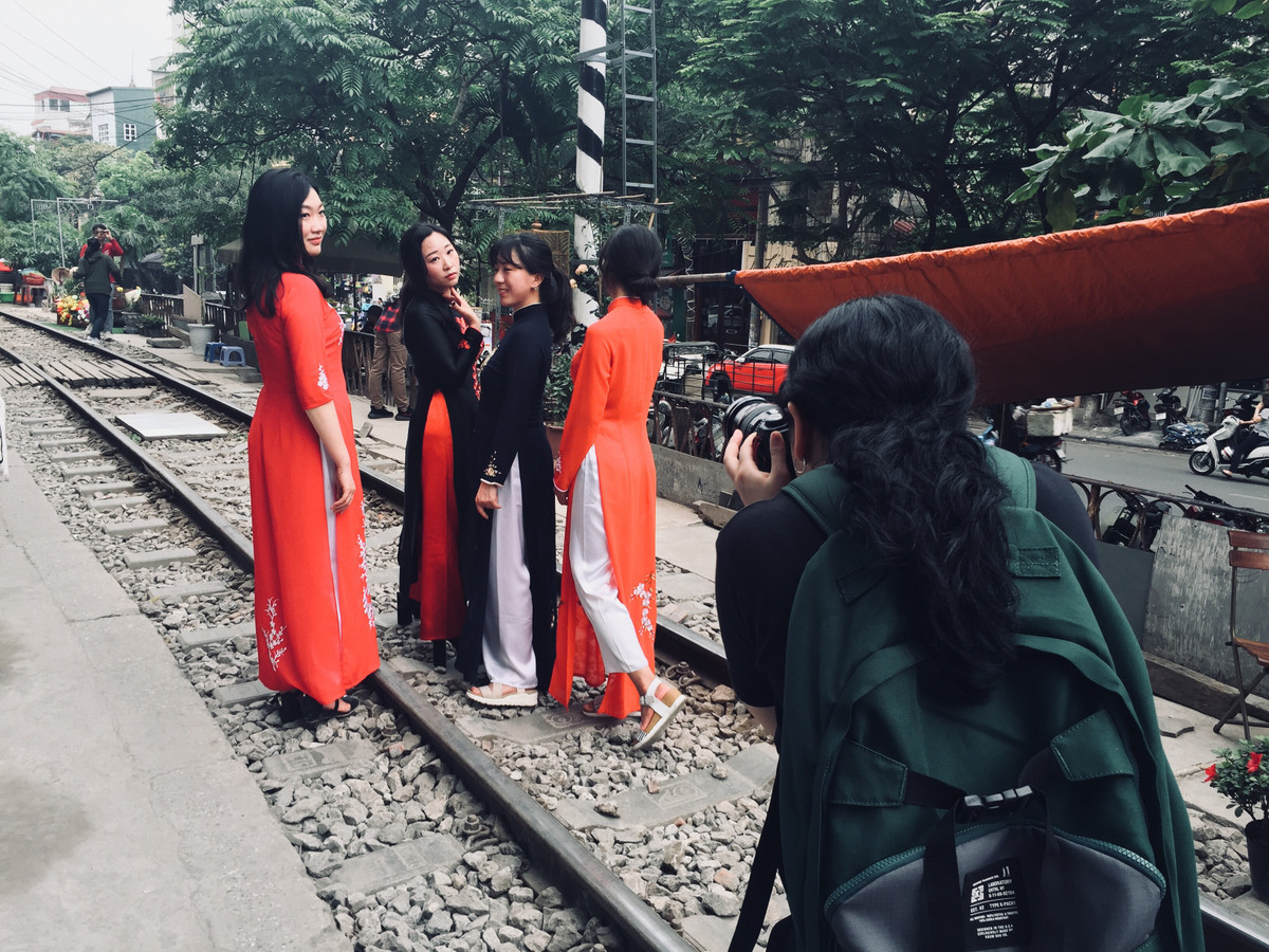 Nhóm du khách Hàn Quốc thích thú chụp ảnh trong tà áo dài tên đường ray tàu.