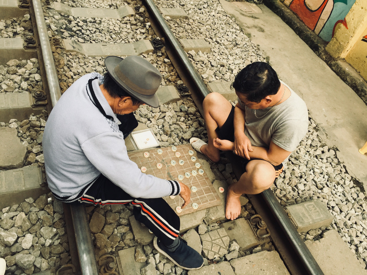Nhiều người còn bê hẳn bàn cờ ngồi giữa đường ray.