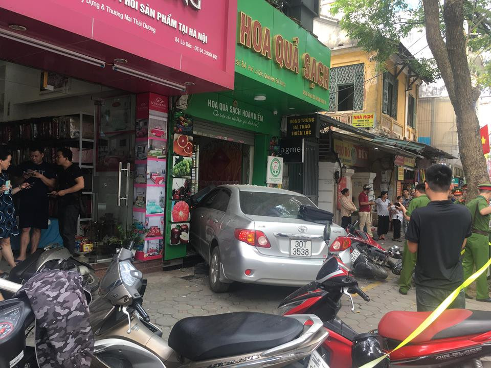 Tại hiện trường nhiều xe máy nằm la liệt trên vỉa hè, chiếc Toyota bị hư hỏng nặng phần đầu, túi khí bung. 