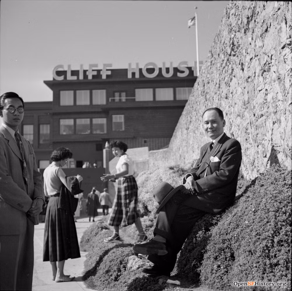 Hai người đàn ông trong đoàn tạo dáng chụp ảnh tại vách đá hướng ra biển. Ảnh: Opensfhistory.org.