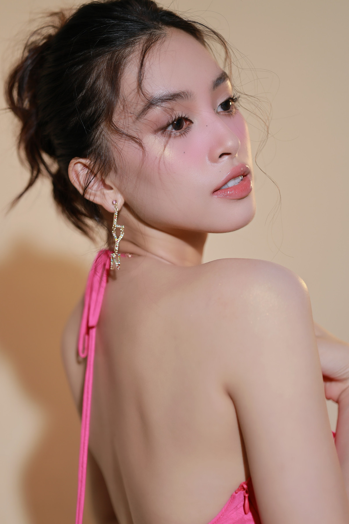 Nàng hậu sinh năm 2000 lựa chọn bộ cánh màu hồng cùng lối make up nhẹ nhàng khoe lưng trần vô cùng quyến rũ.