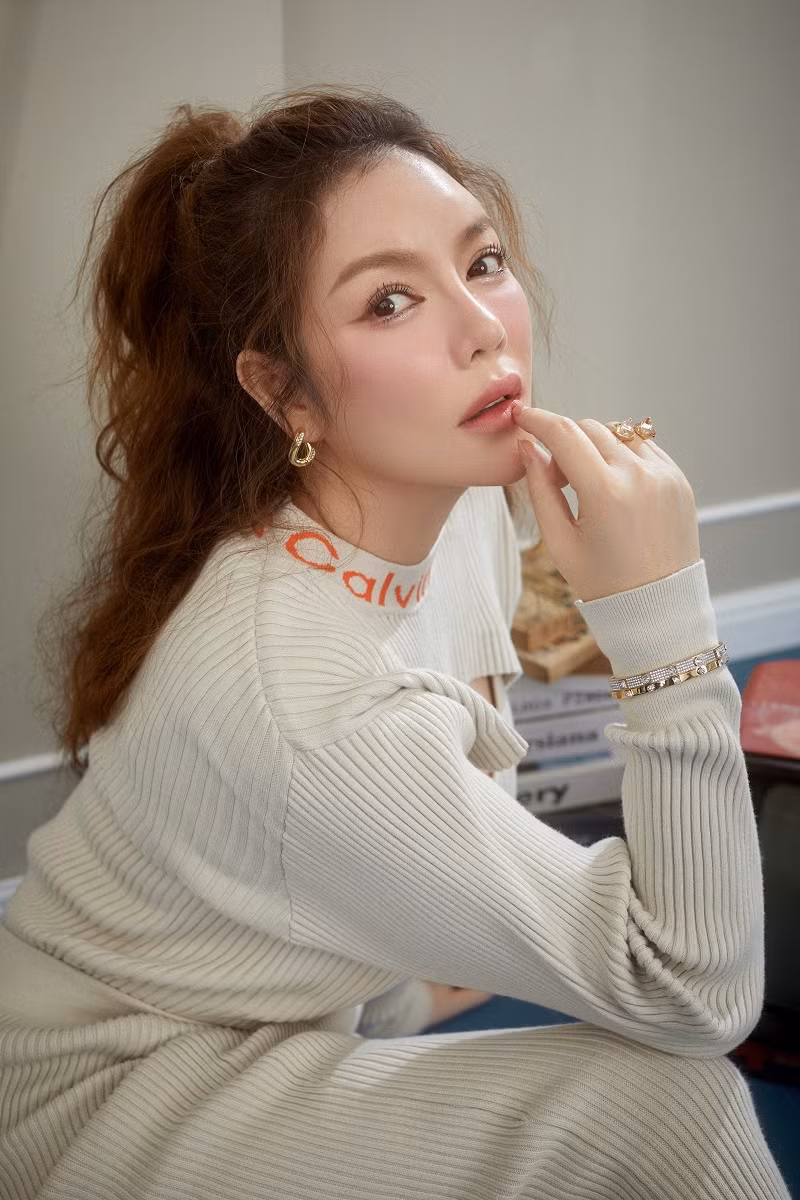 Nữ diễn viên đánh tóc rối nhẹ nhàng, trang điểm tông hồng cam ngọt ngào, tươi tắn.