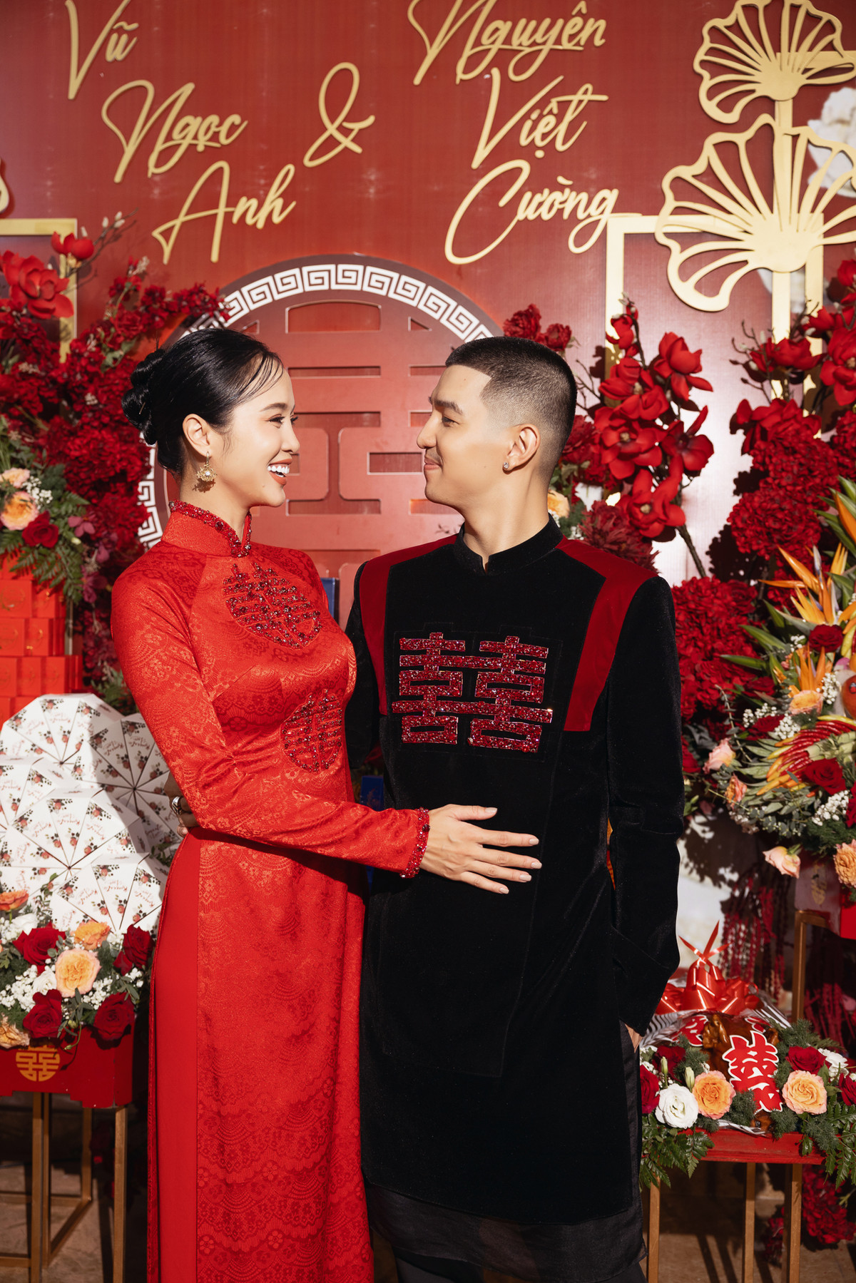 Cô dâu Vũ Ngọc Anh mặc áo dài đỏ họa tiết chữ hỷ sánh đôi cùng chú rể. Ảnh: Saostar