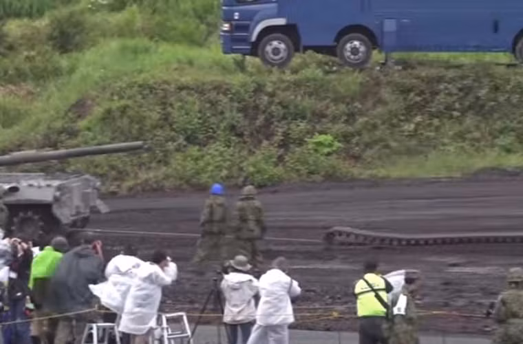 Xích xe tăng được kéo theo khi mà xe cứu kéo đưa Type 74 rời hiện trường.