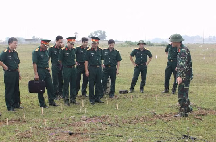 Các cán bộ kiểm tra một bãi tạo giả đã được bố trí thiết bị điều khiển nổ.