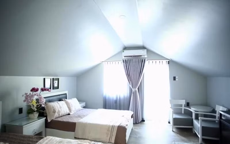 Phòng ngủ ấm cúng, ngập ánh sáng với phần 1 tường được thay bằng kính.