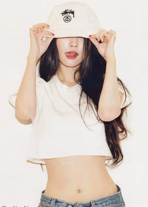 IU khoe vòng eo kiến trong set trang phục áo crop top và quần jean.